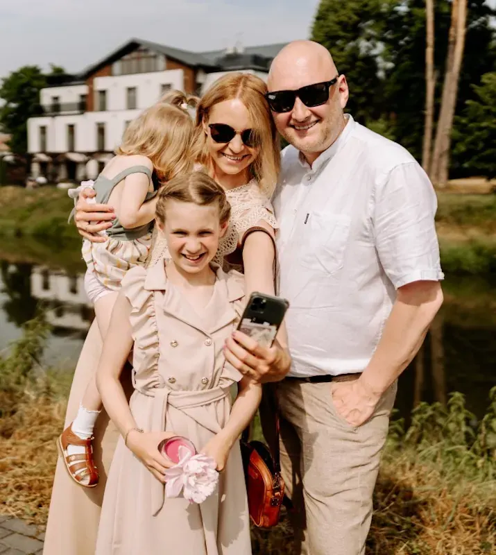 Familienfoto vor einer Villa am Wasser