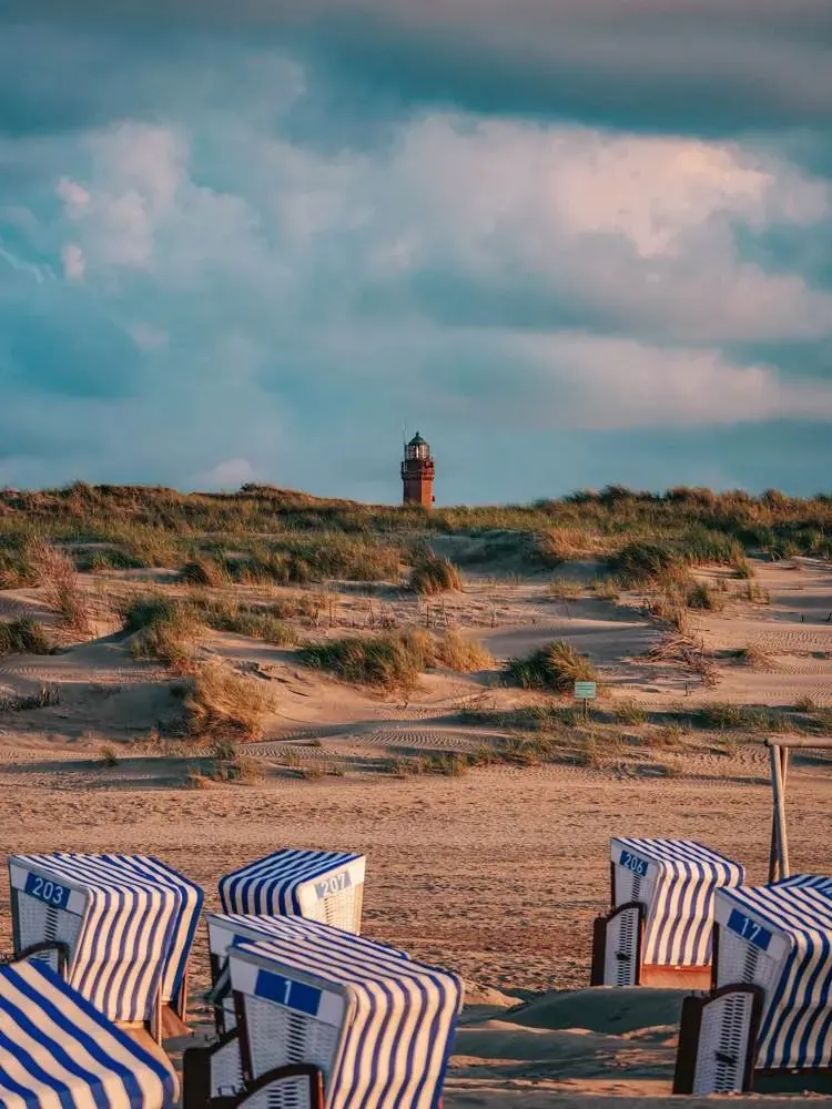 Kosze plażowe w wydmach z latarnią morską