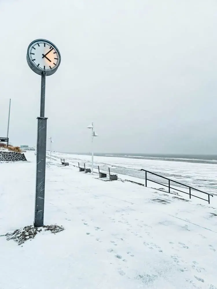 Zegar na zaśnieżonej promenadzie